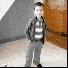 a young boy is standing in a room with his hands in his pockets ..