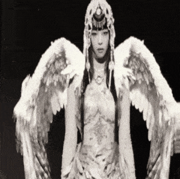 a black and white photo of a woman in a costume with wings .