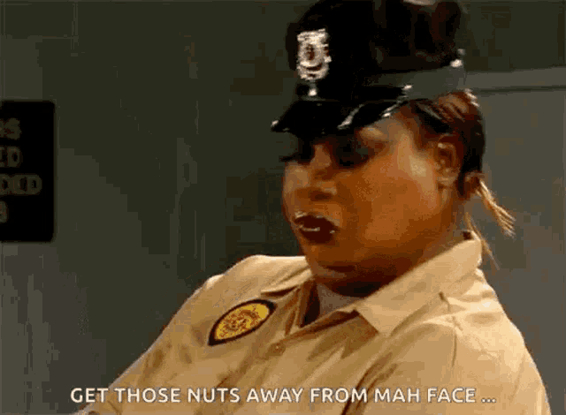a woman in a police uniform is talking about getting nuts away from mah face .