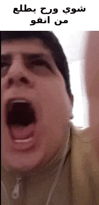 a man is screaming with his mouth open in a video while wearing headphones .