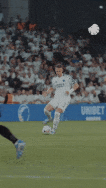 a blurry picture of a soccer game with a goalie diving to catch a ball
