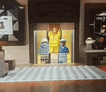 a group of lego figures standing in an elevator with a sign that says ' vega ' on it