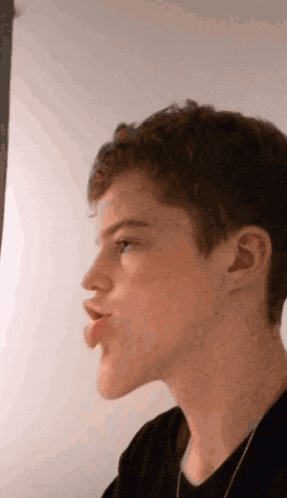 a close up of a young man 's face with his tongue out