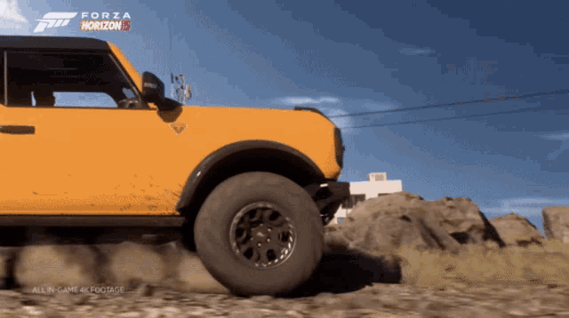 a yellow ford bronco is driving down a dirt road in forza horizon