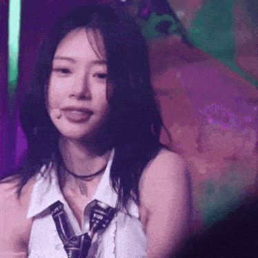 a close up of a woman wearing a tie and a choker on a stage .