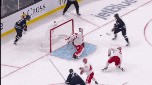 a hockey game is being played in front of a jetblue advertisement