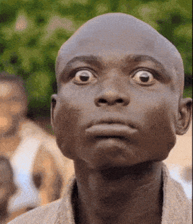 a close up of a bald man 's face with a surprised look on his face