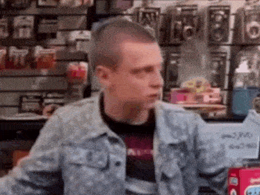 a man in a military jacket is sitting in a store .