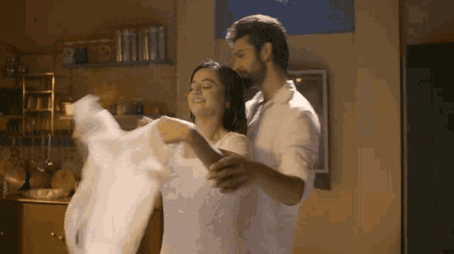 a man is holding a woman in a white dress