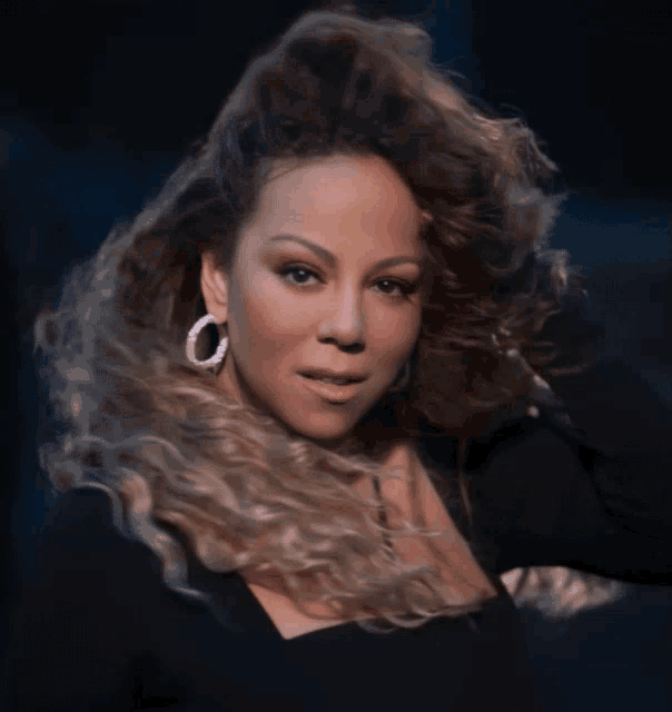 a close up of a woman wearing hoop earrings and a black top