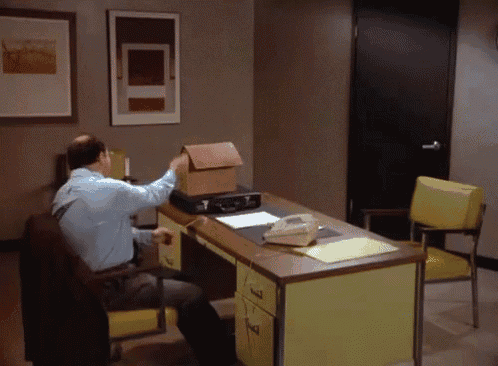 a man is sitting at a desk with a box on top of it that looks like a house