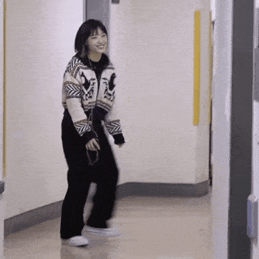 a woman in a black and white sweater is dancing