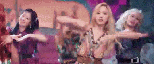 a group of women are dancing together on a stage in a room .