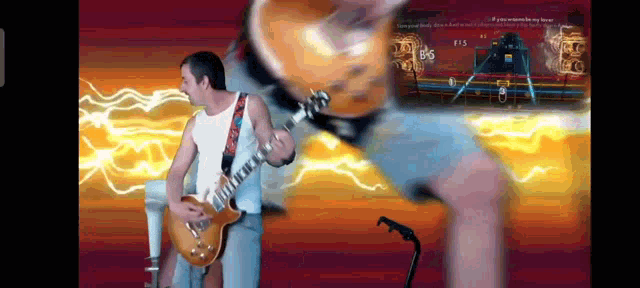 a man is playing a guitar in front of a screen that says ' if you wanna be my hero '