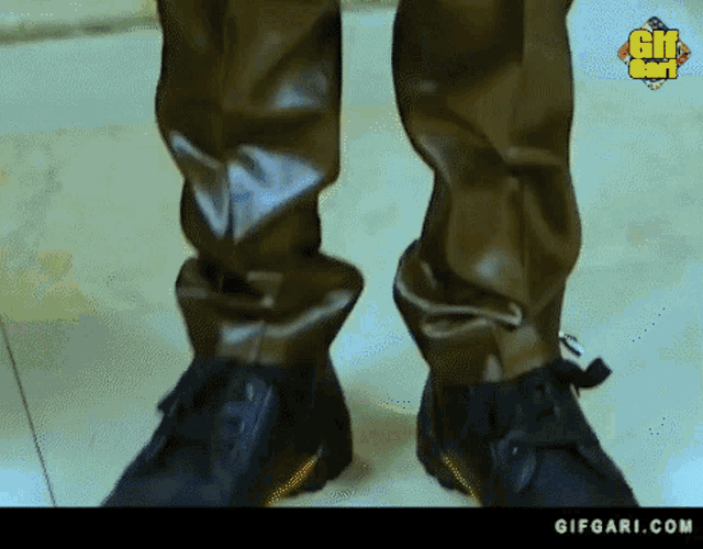 a close up of a person 's feet wearing a pair of black shoes .