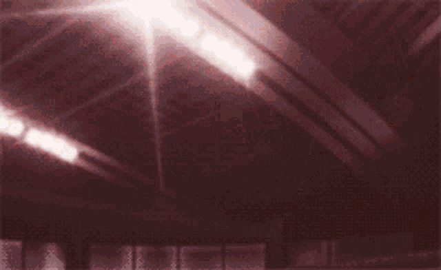 a person 's hands are reaching up in the air in a dark room