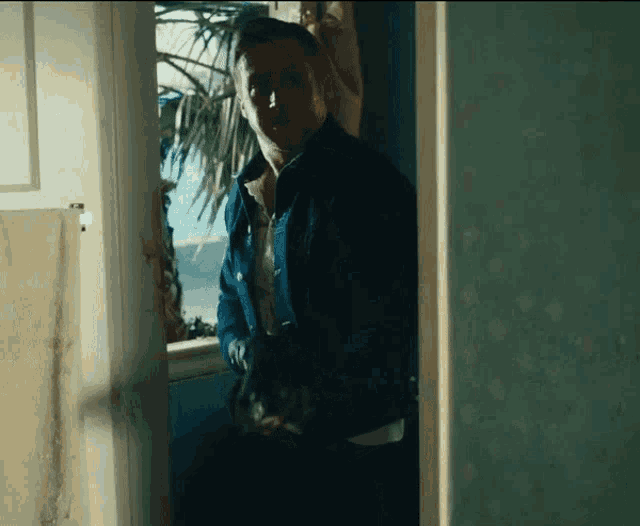 a man in a blue jacket is looking out a window