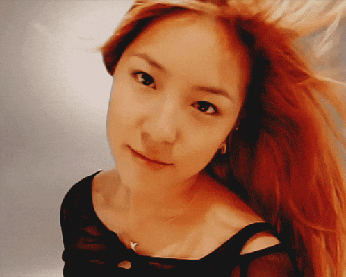 a close up of a woman 's face with red hair