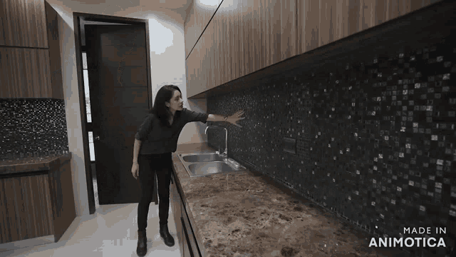 a woman standing in a kitchen with the words made in animatica on the bottom right