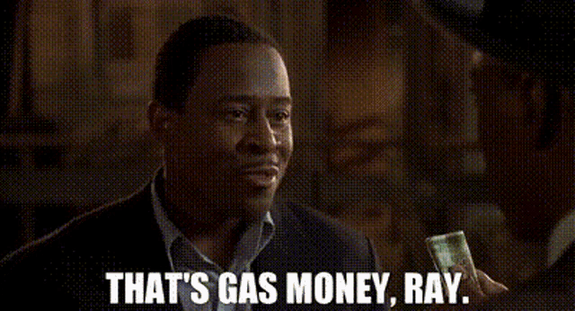 a man in a suit is smiling and holding a piece of money .