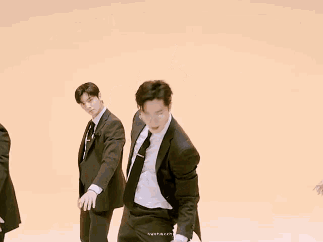 a group of men in suits and ties are dancing and one man is wearing glasses