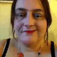 a close up of a woman 's face with a necklace and earrings .