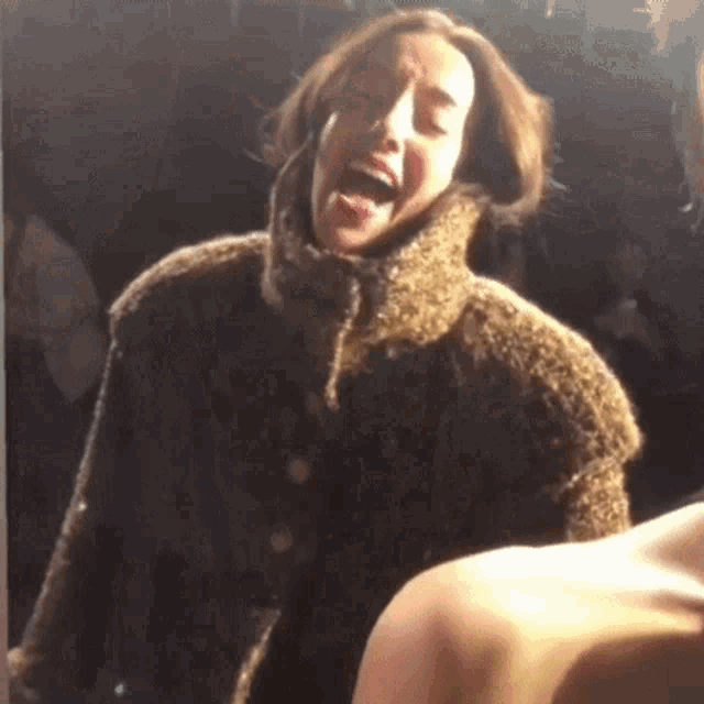a woman in a fur coat with her tongue out