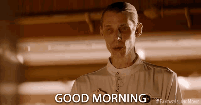 a man wearing a white shirt says good morning
