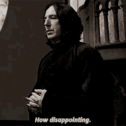 a man in a black robe is standing in front of a window and holding a book and saying `` how disappointing . ''