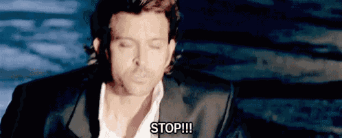 a man in a suit and white shirt is sitting in a chair with his eyes closed and says `` stop '' .