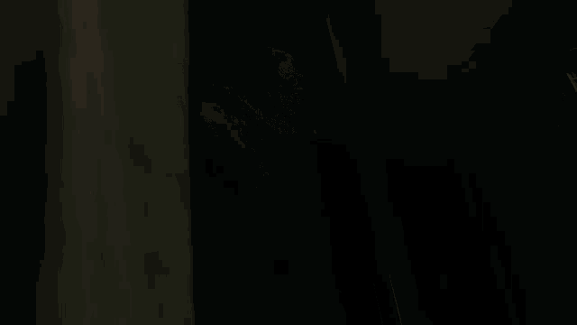 a statue of a man with a beard is standing in the dark looking at the camera .
