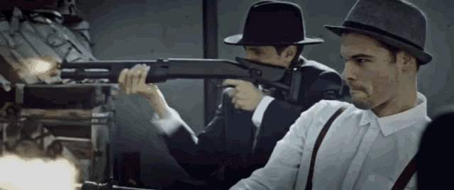 a man in a hat is holding a shotgun