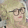 a woman wearing glasses and a wig is looking at the camera .