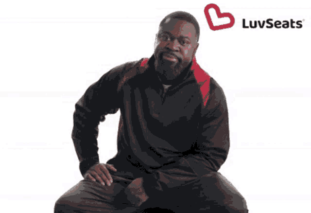 a man is sitting in front of a luvseats logo