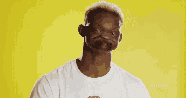a man wearing a white shirt with the word zeus on the bottom right