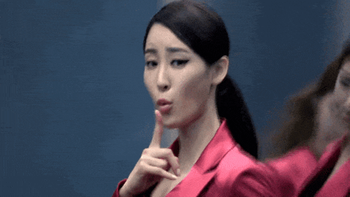 a woman in a pink jacket is pointing at another woman