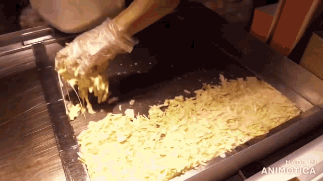 a tray of shredded cheese with the words made in animatica on the bottom right