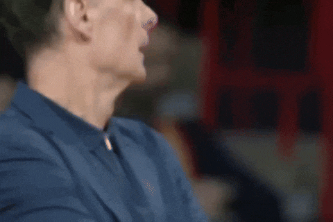 a close up of a man 's face in a blue shirt and jacket .