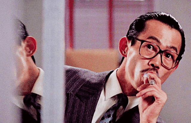 a man with glasses and a mustache is smoking a cigar