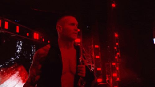 a man in a black shirt holds a trophy in a dark room