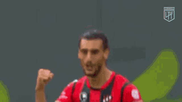 a soccer player is pointing at the camera with his finger .