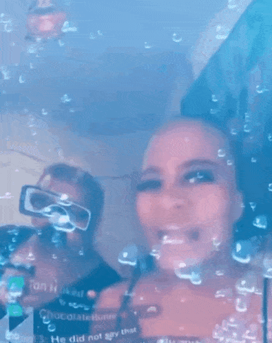 a man and a woman are standing in a bathtub with bubbles coming out of the window .