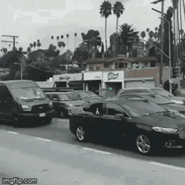 a bunch of cars are driving down a street with a sign that says imgflip.com on the bottom