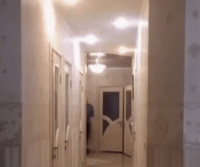 a hallway with a ceiling fan and a door