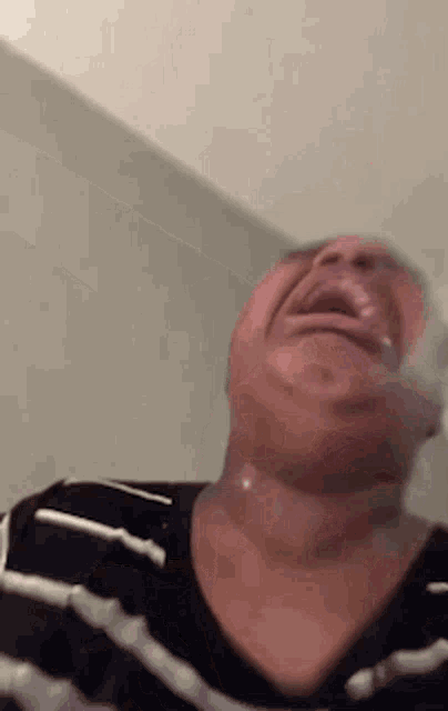 a close up of a person 's face with their mouth open and a striped shirt .