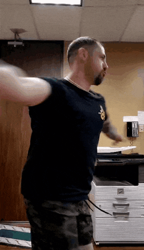 a man in a black shirt with a pineapple on it is dancing