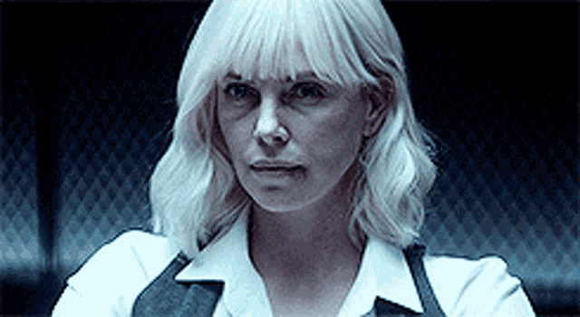 a woman with white hair is wearing a white shirt and black vest