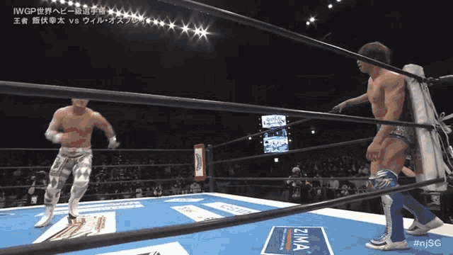 two men in a wrestling ring with a sign that says zima on it