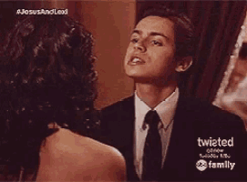 a man in a suit and tie is looking at a woman in a dress