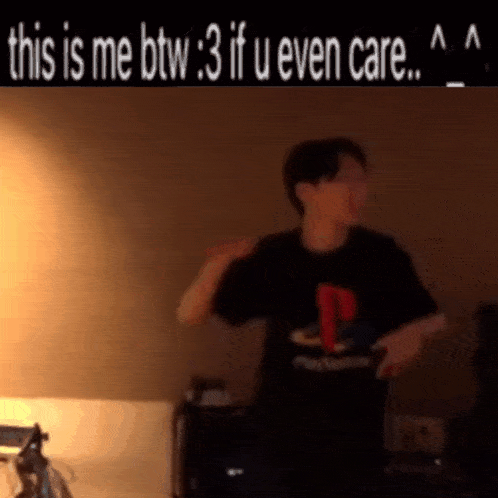 a man in a playstation shirt is dancing in a room
